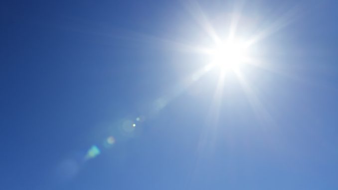 Shining sun at clear blue sky with copy space