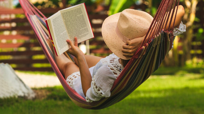 Attractive sexy woman reading book in hammock.
